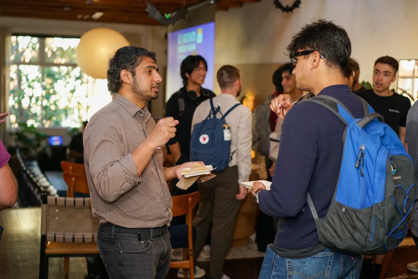 Developers talking over food and drinks at AI Agents Builder Night