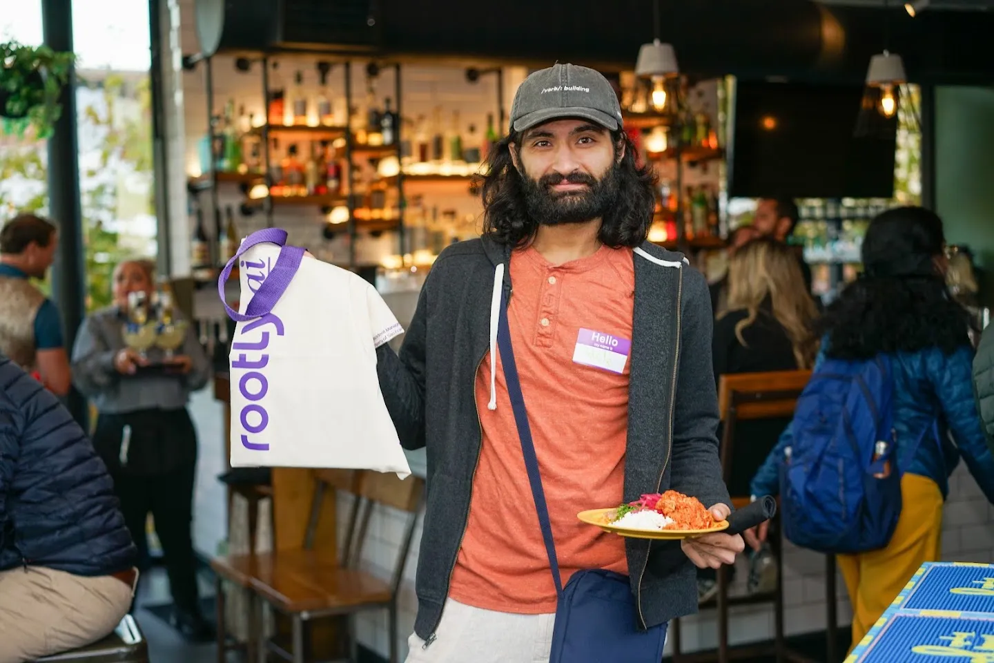 Guest holding a Rootly gift bag beside the bar
