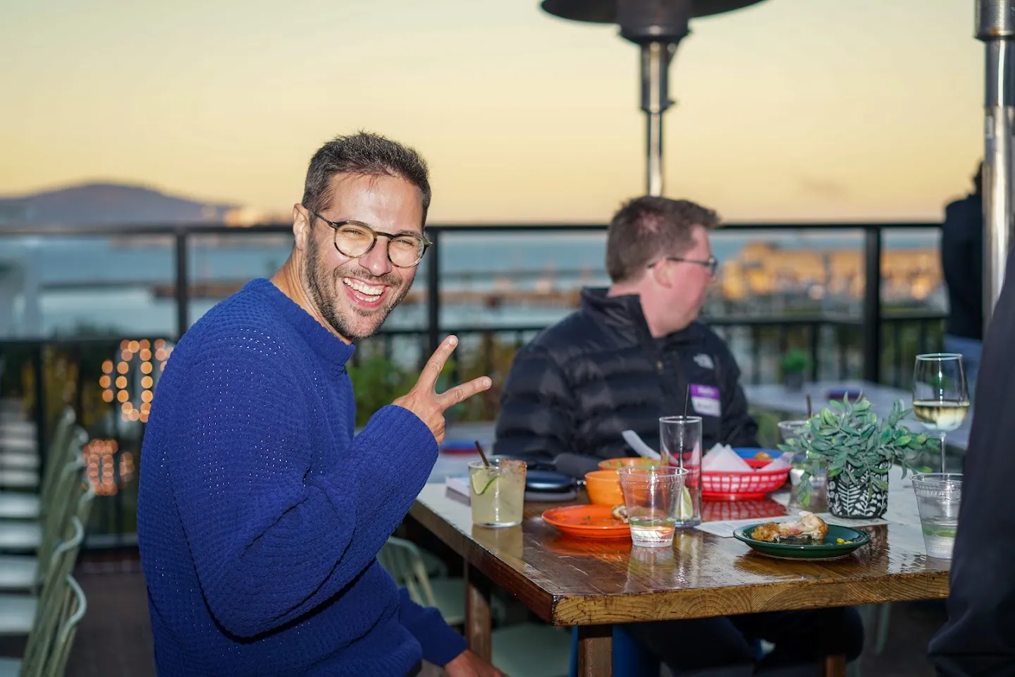 Guest seated on the terrace overlooking the Bay at sunset
