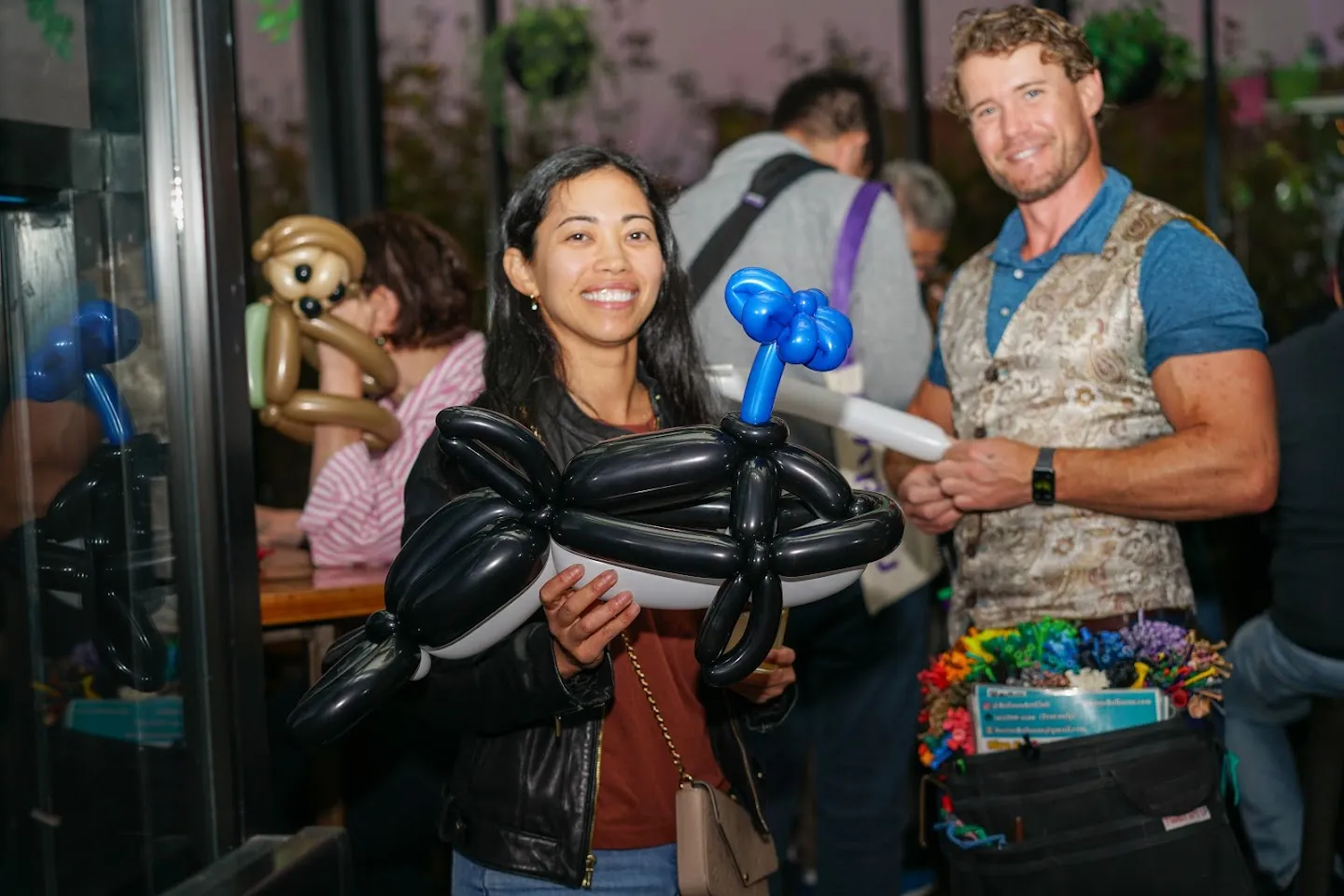 Guest and balloon artist holding balloon sculptures