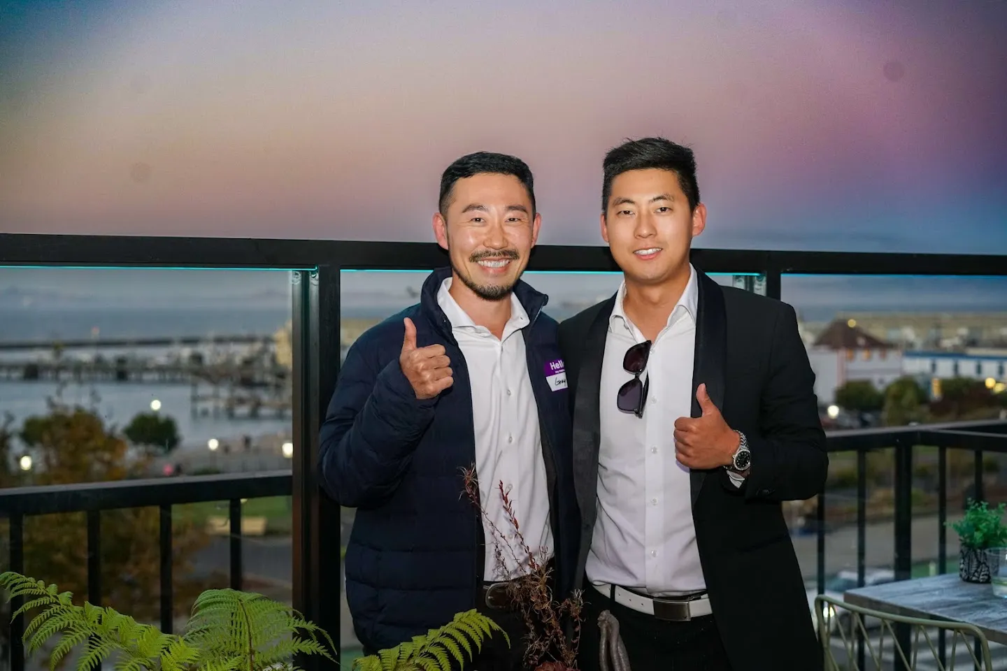 Two guests posing against the sunset over the Bay