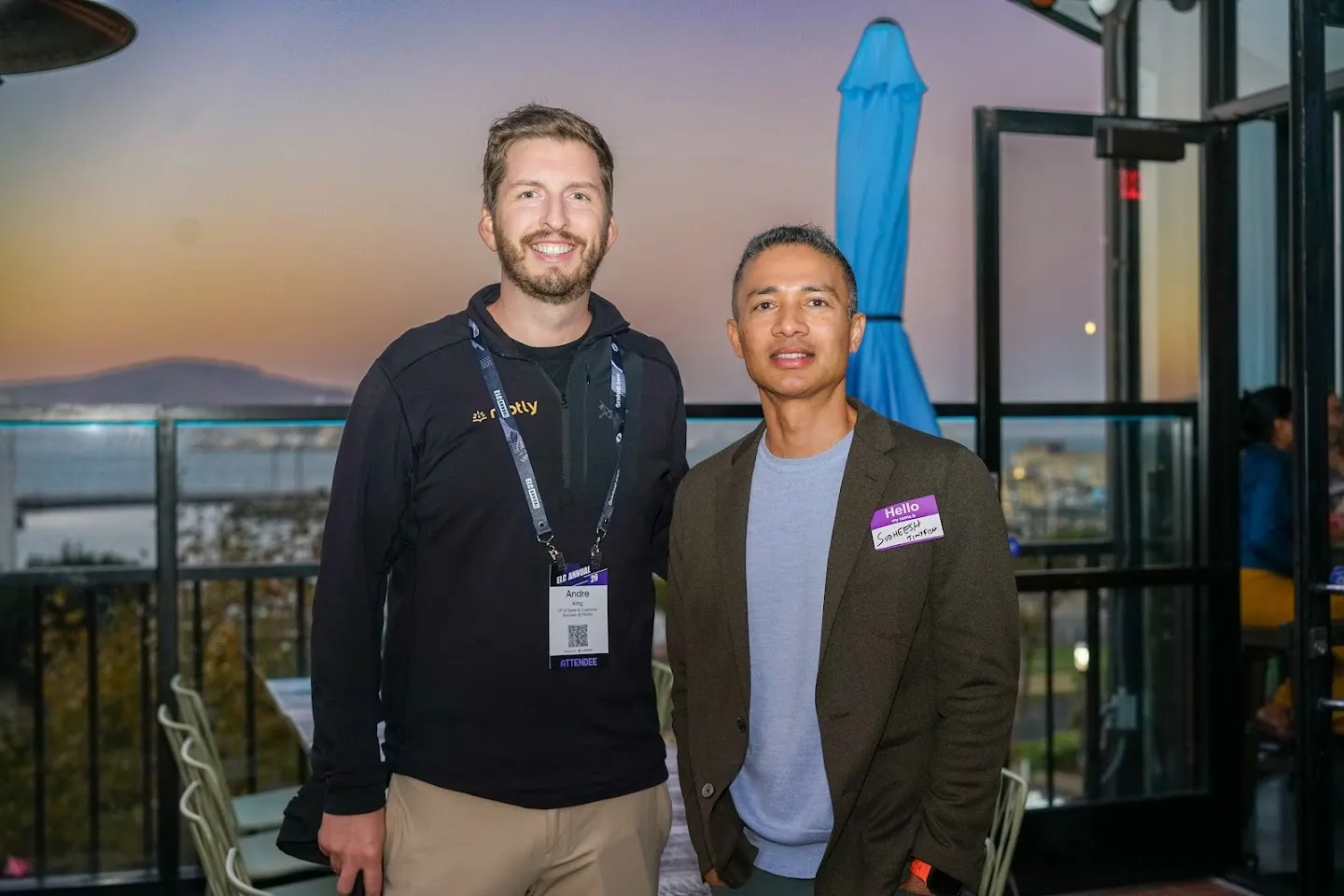 Two attendees on the terrace at dusk