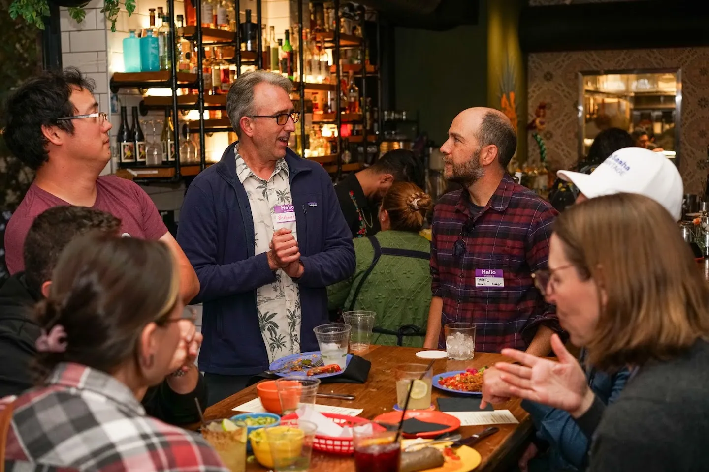 Guests talking around a table with food and drinks