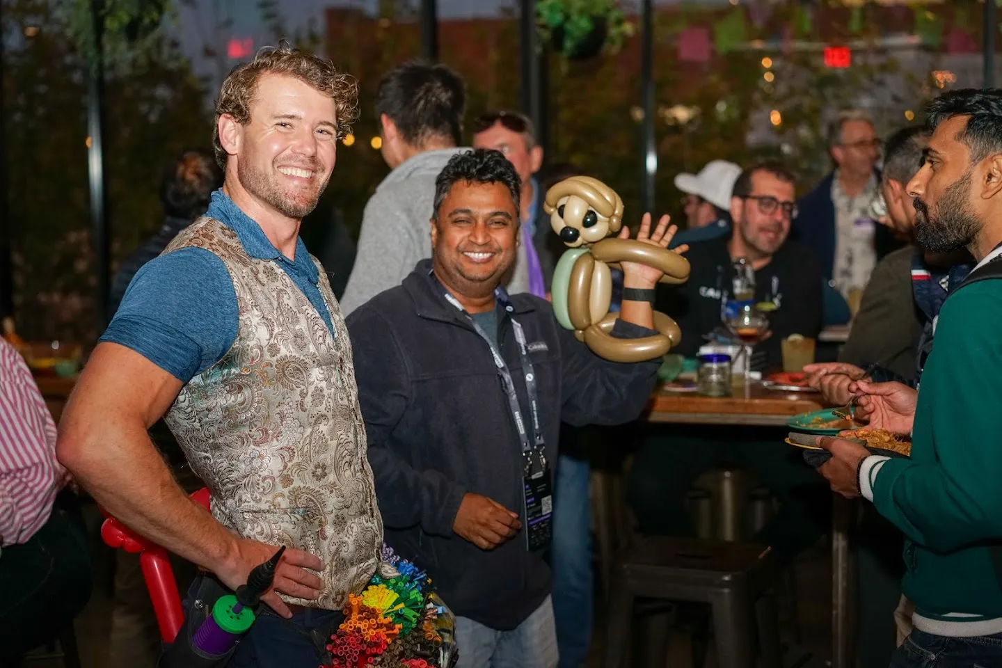 Guest posing with the balloon artist and a balloon sculpture