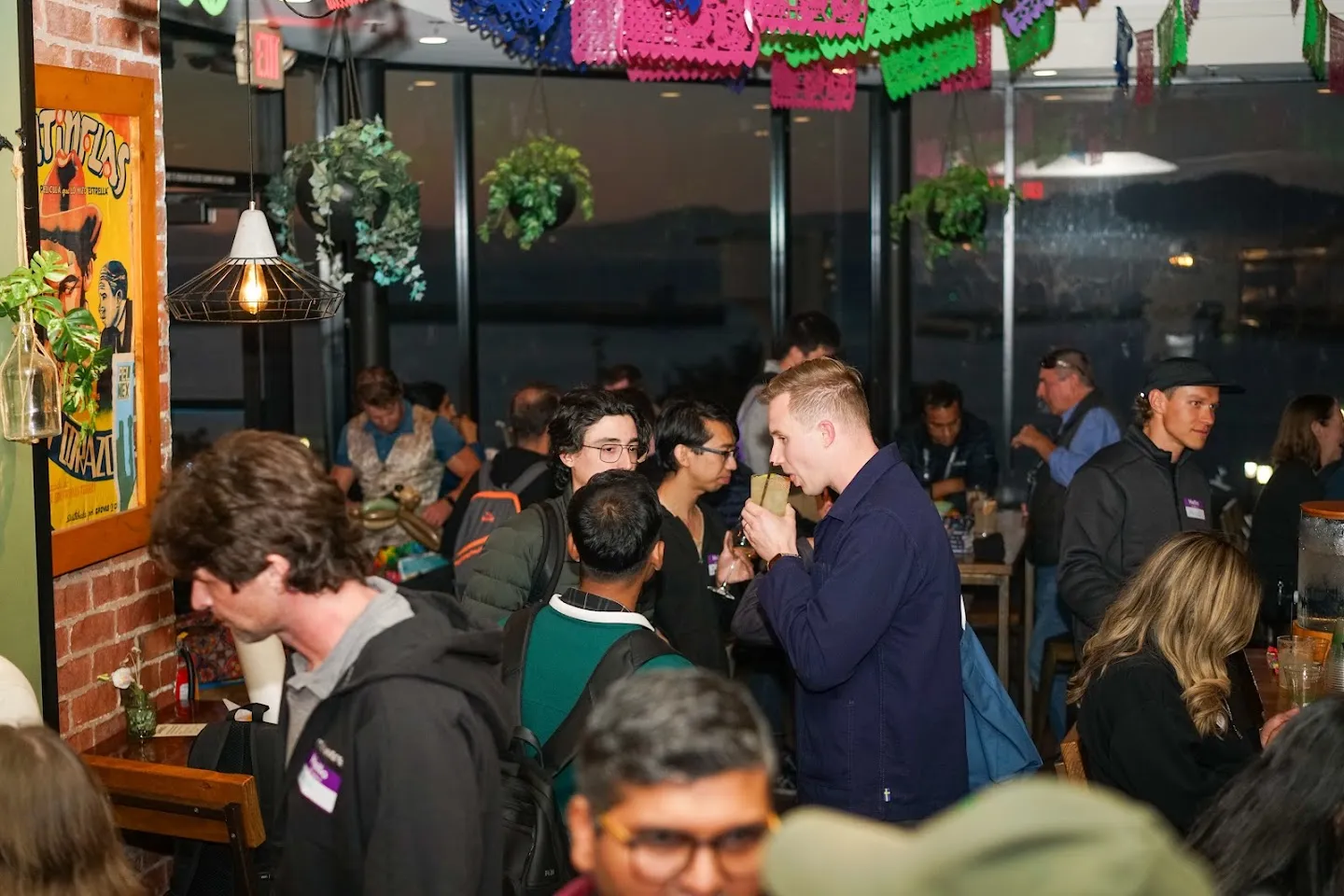 Guests filling the terrace beneath string lights
