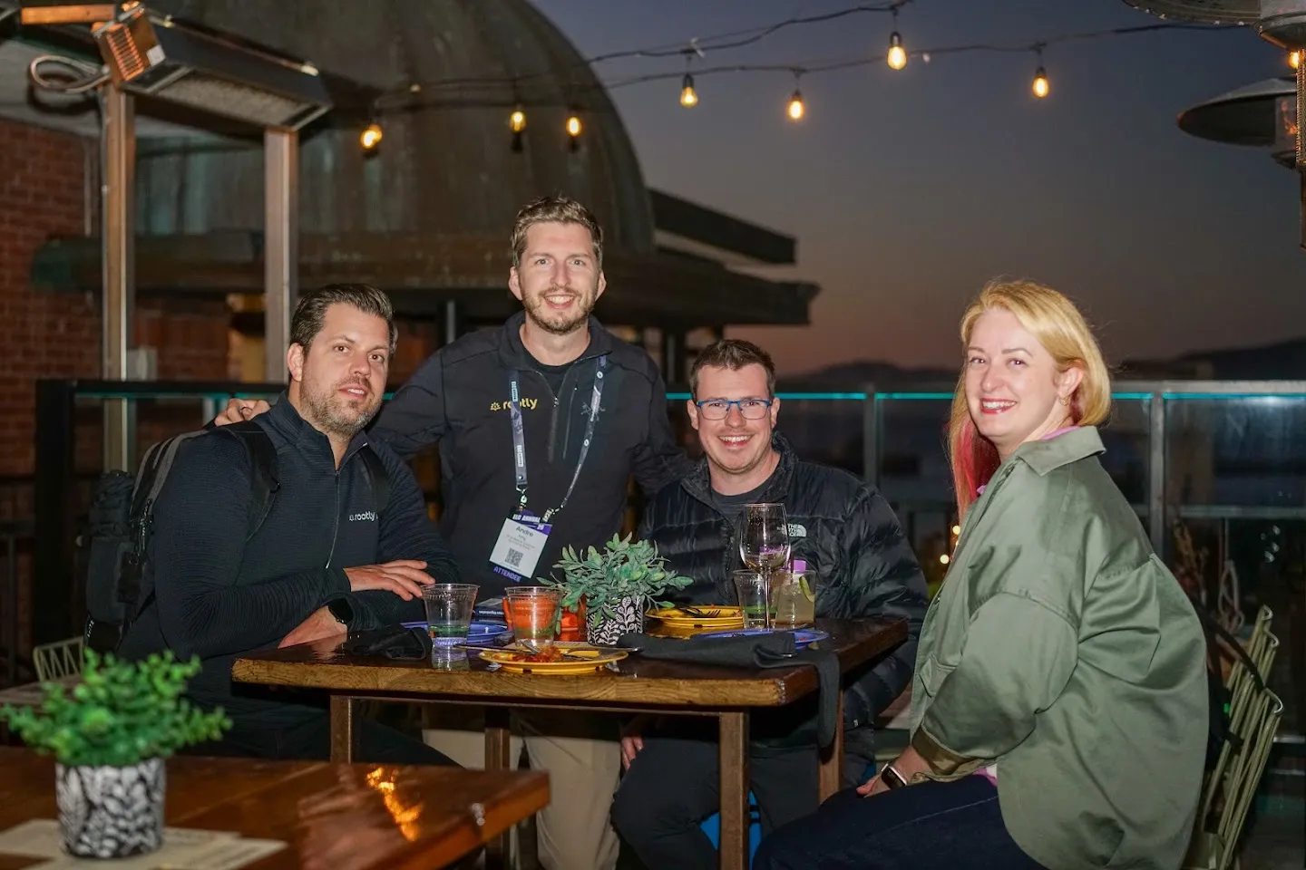 Four guests gathered around a terrace table