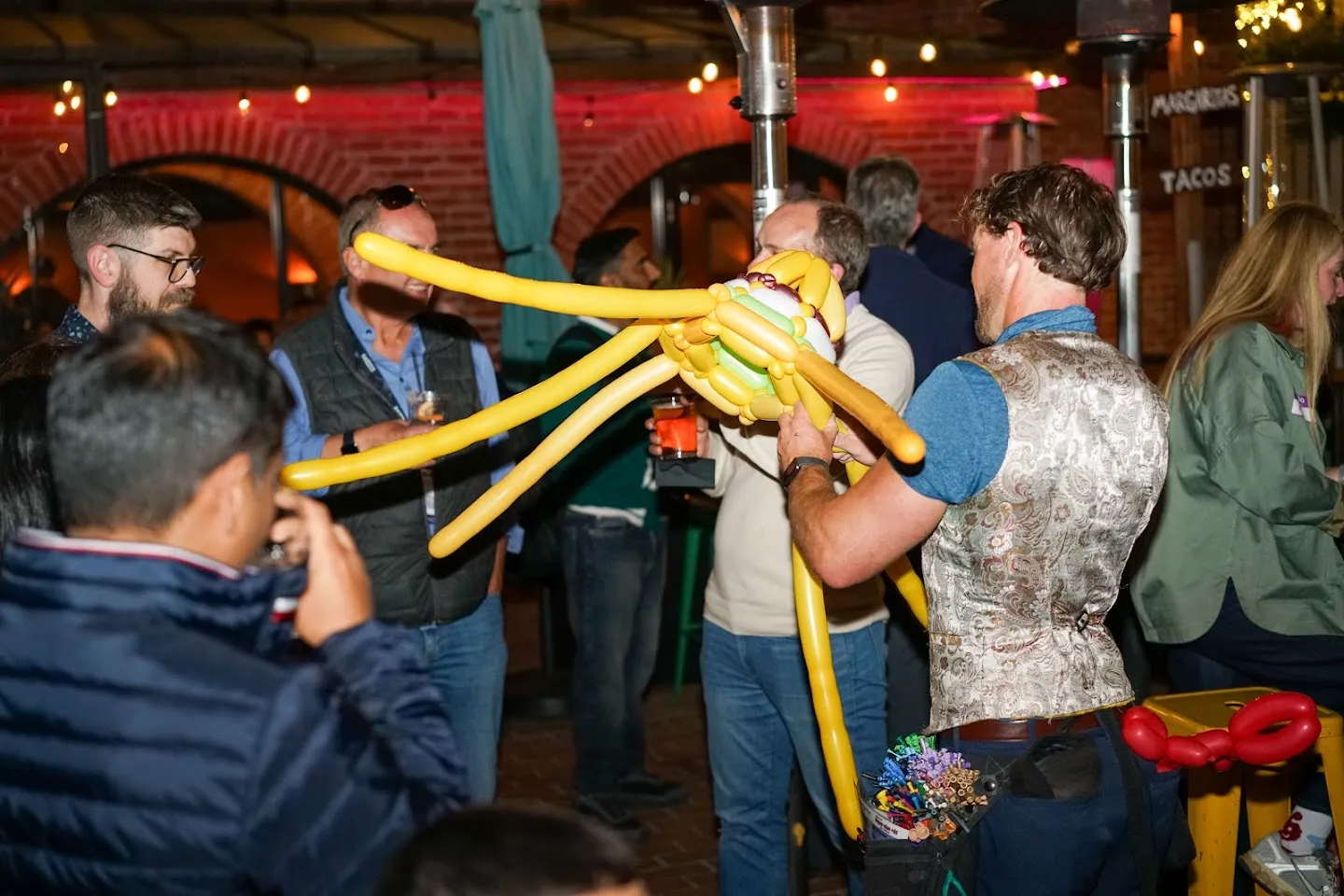Balloon artist assembling a yellow balloon hat