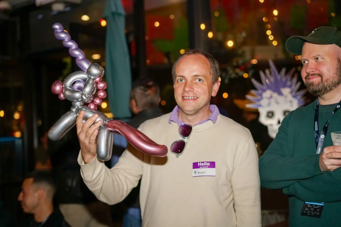 Guest holding a purple and silver balloon animal