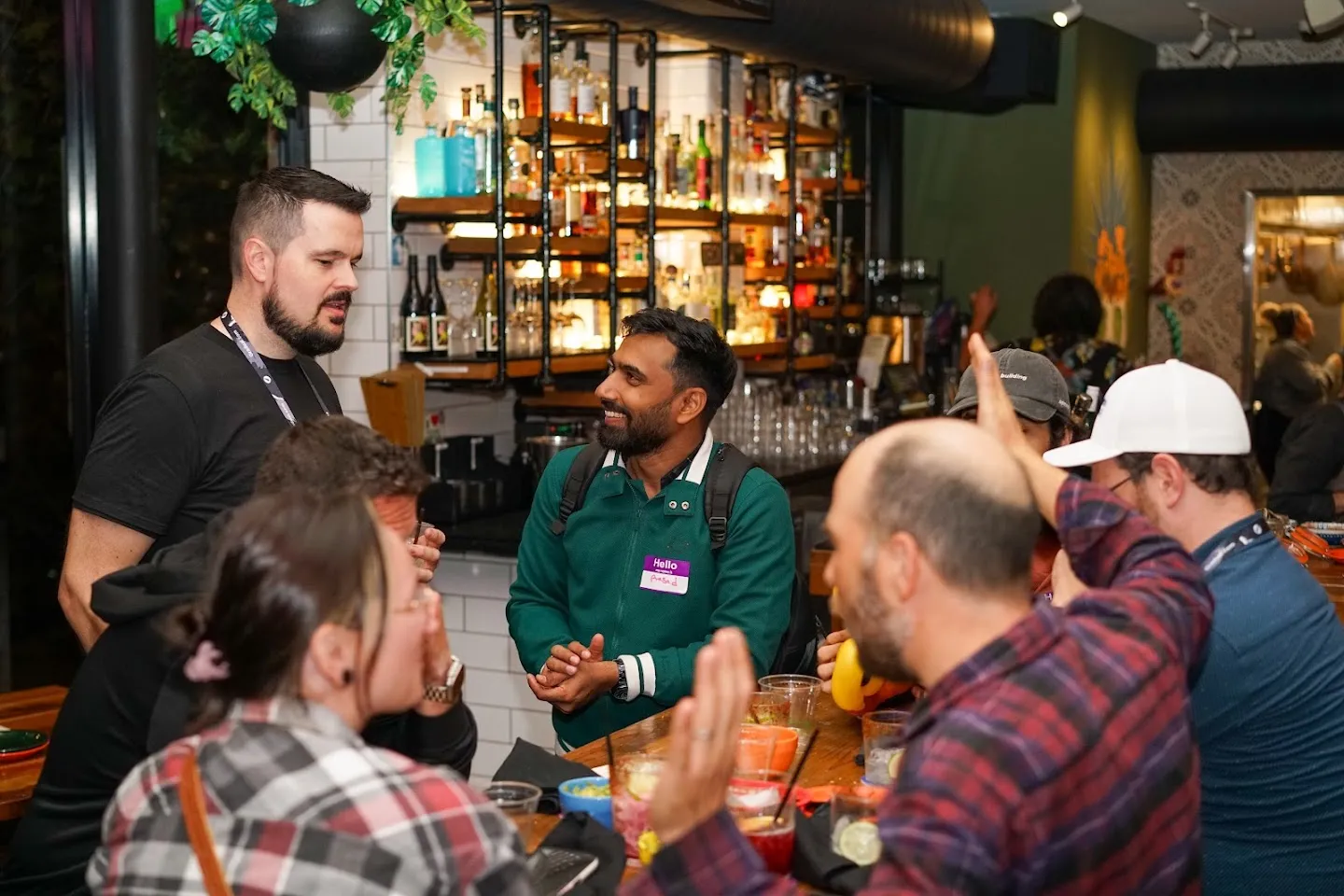 Guests chatting at a table beside the bar