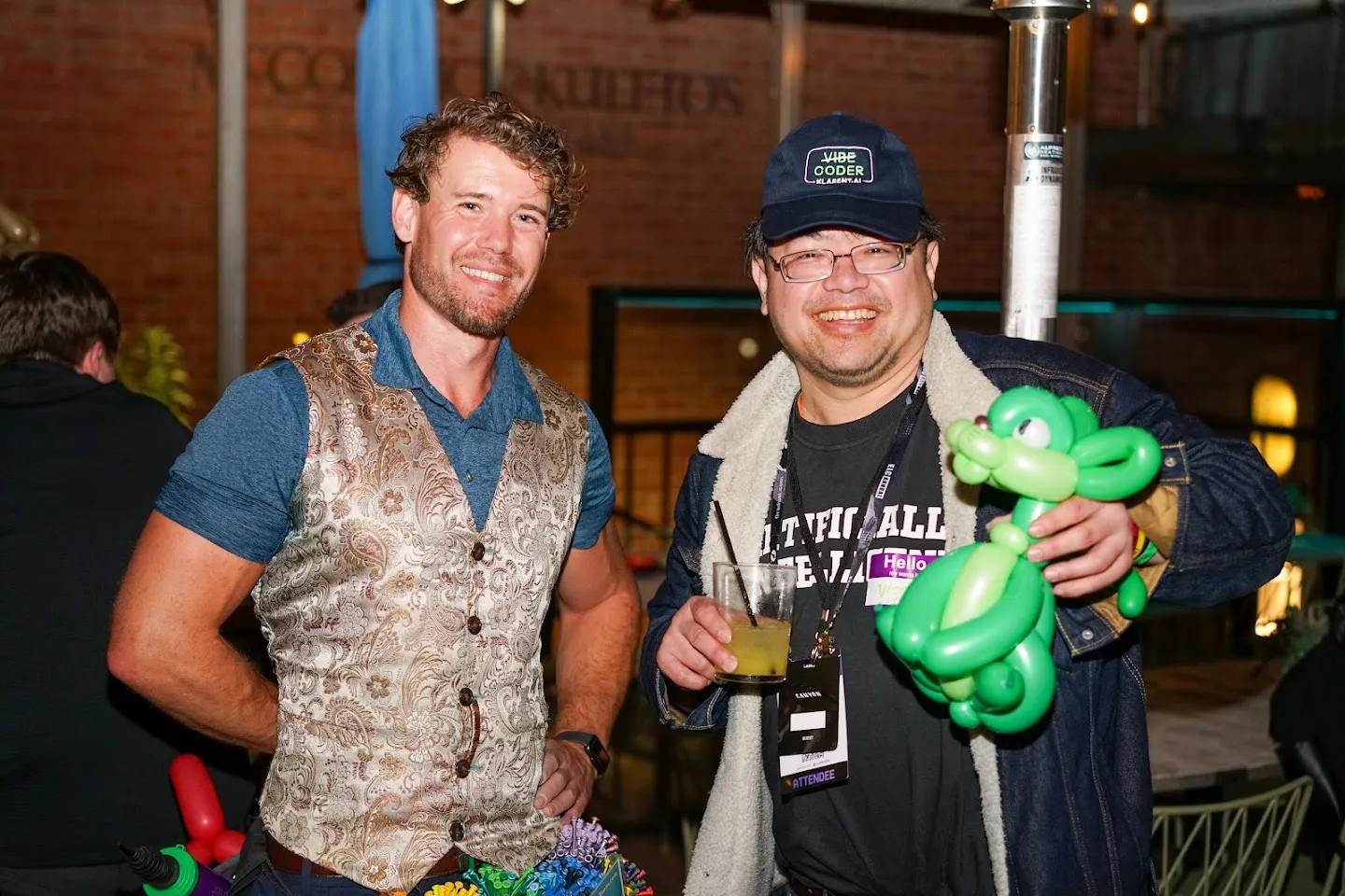 Balloon artist and guest smiling with a green balloon sculpture