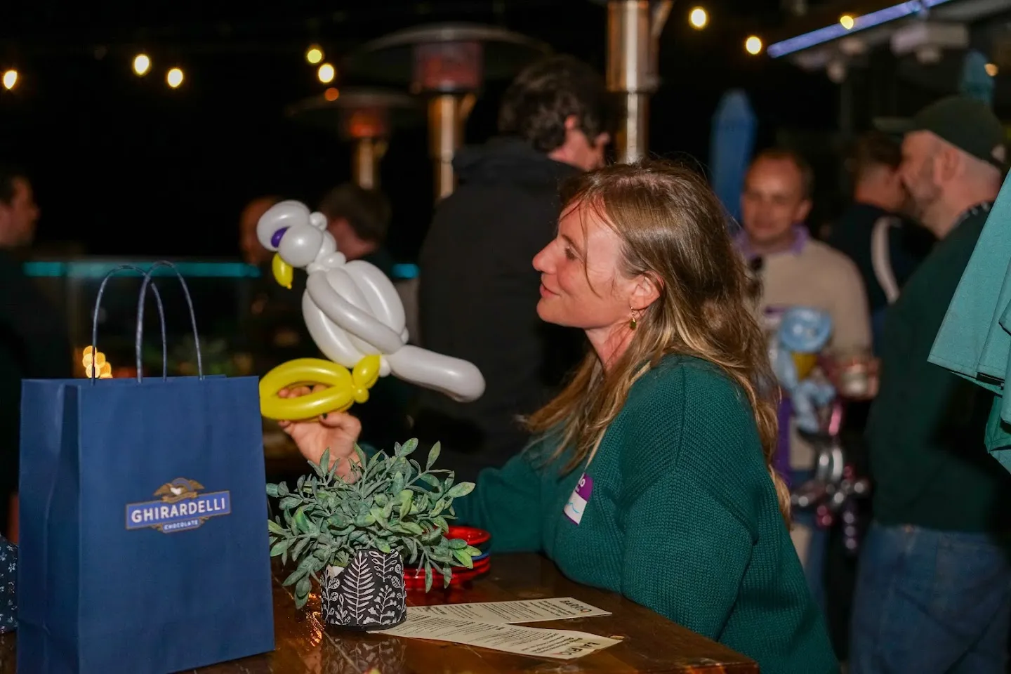 Guest holding a balloon bird beside the terrace table