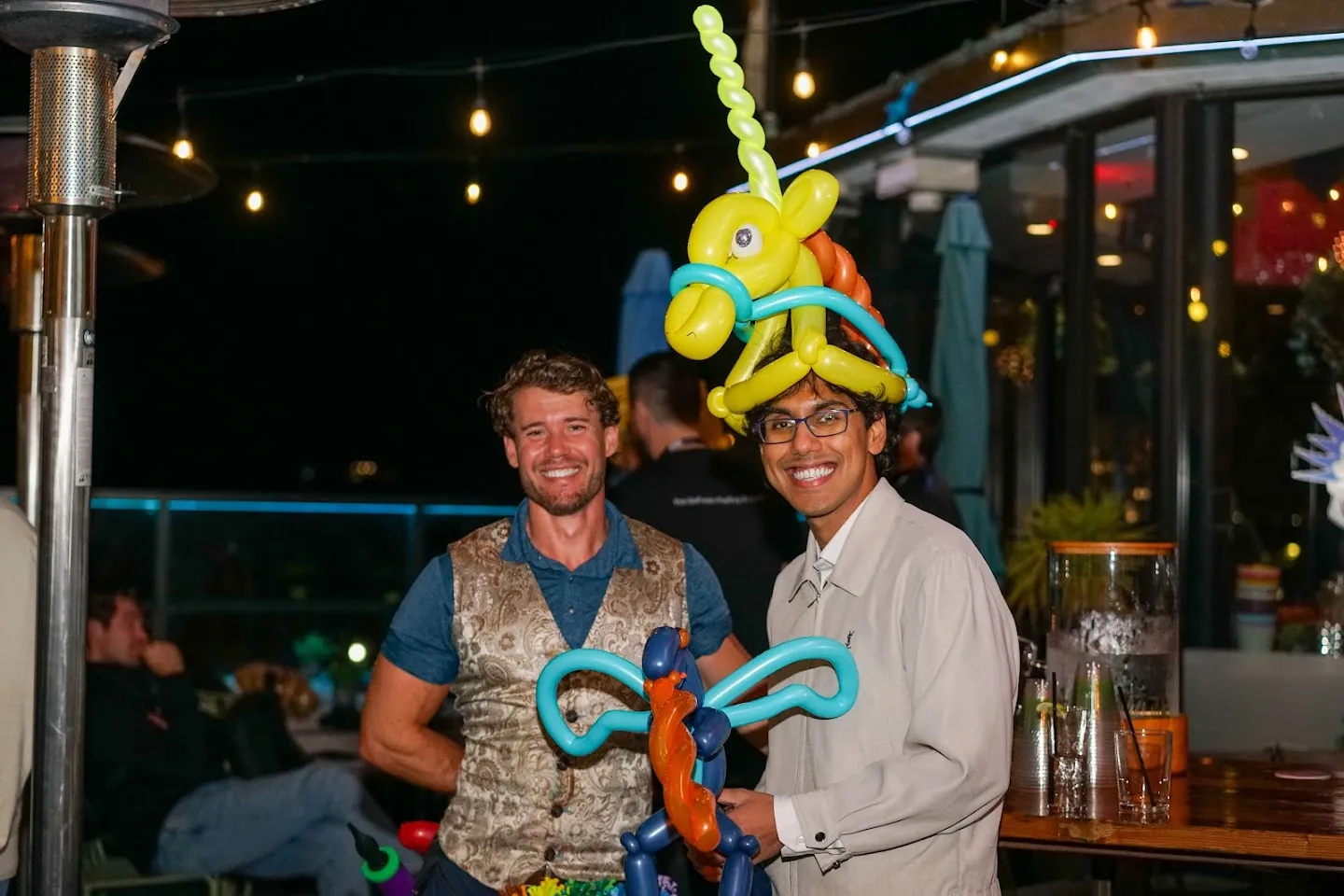 Balloon artist and guest posing with colorful balloon creations