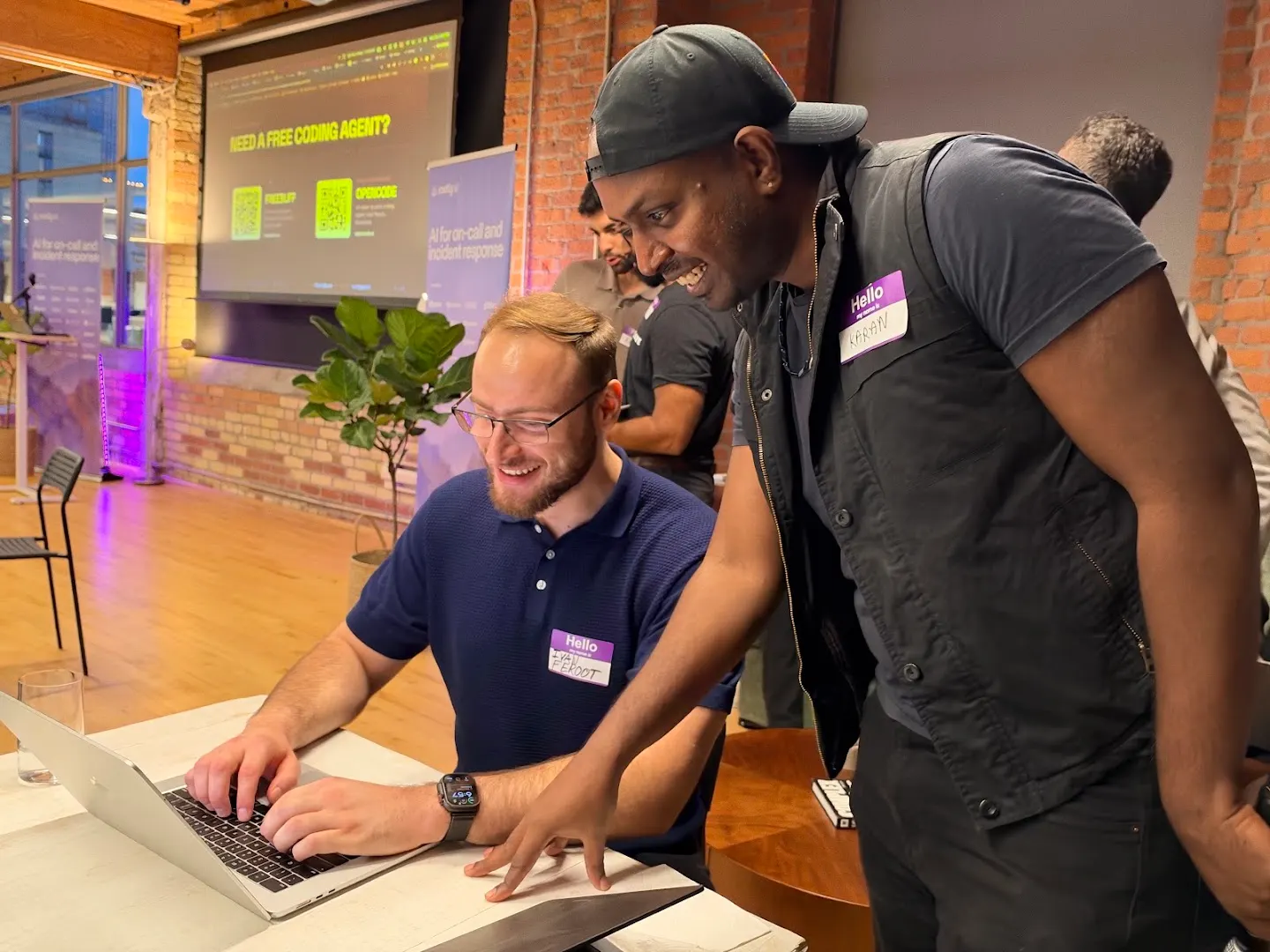 Attendees working together on laptops at Cloudflare x Rootly (photo 7)