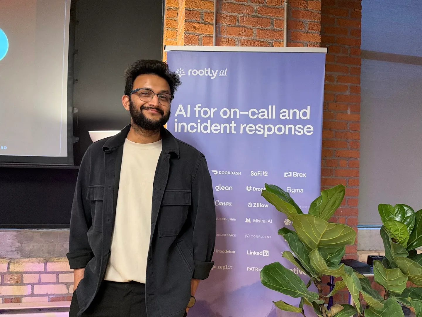 Presenters with microphones beside the screen at the Cloudflare AI agents workshop