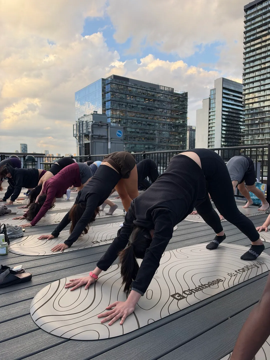 Participants stretching through standing yoga poses against the Toronto skyline