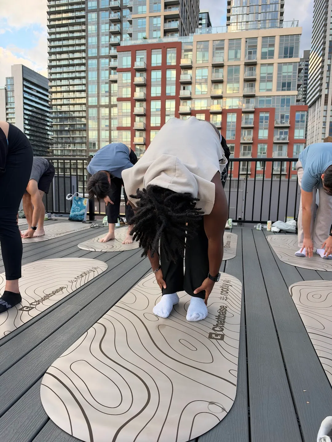 Participants stretching through standing yoga poses against the Toronto skyline