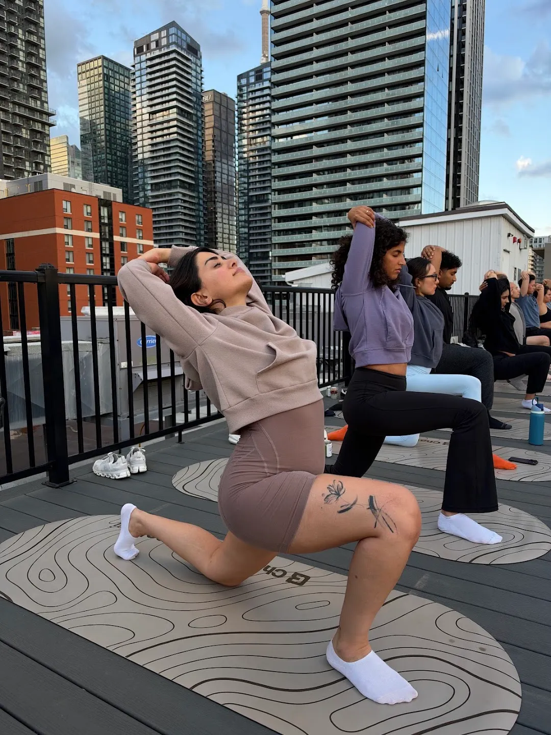 Participants stretching through standing yoga poses against the Toronto skyline