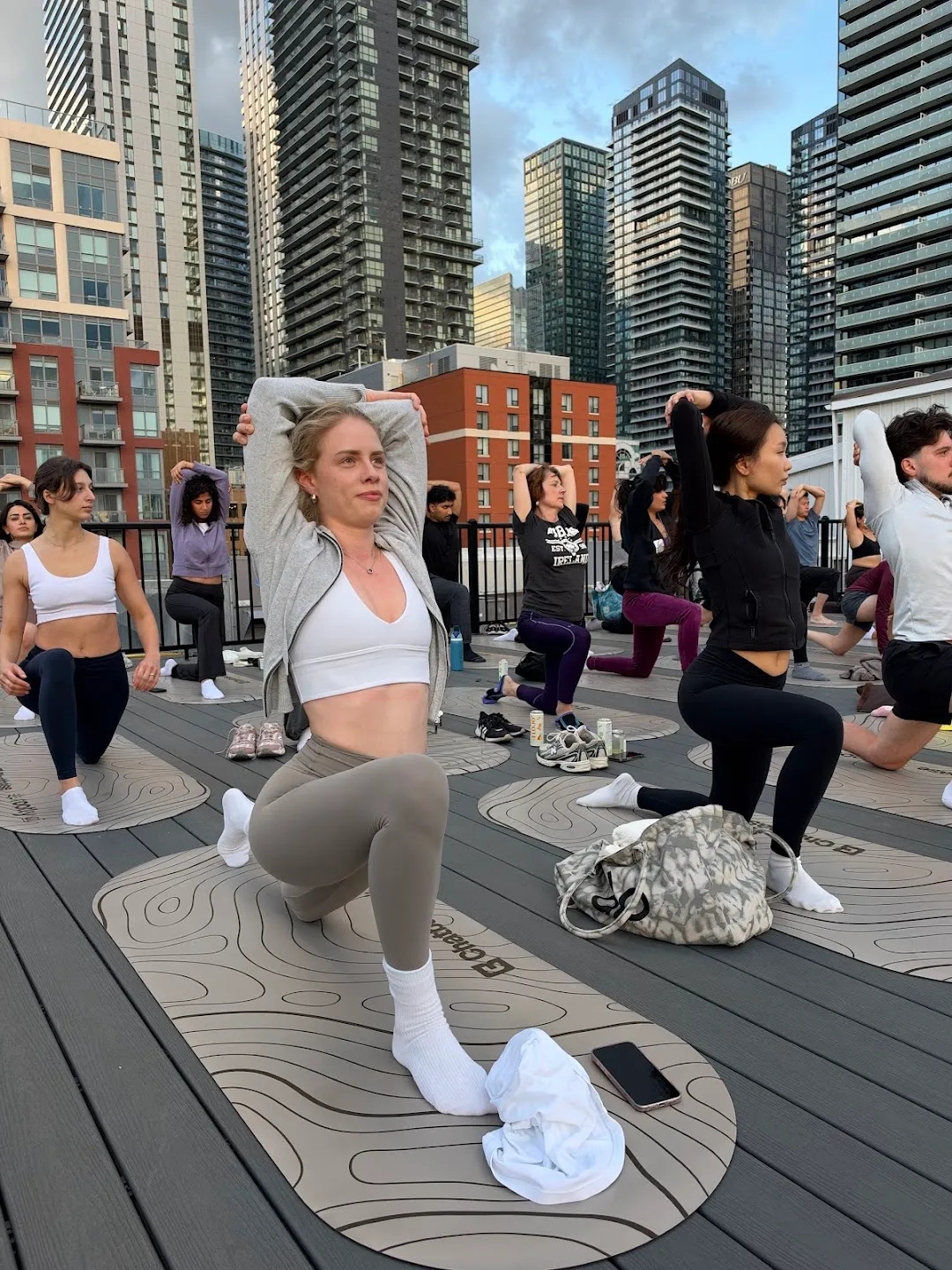 Participants stretching through standing yoga poses against the Toronto skyline