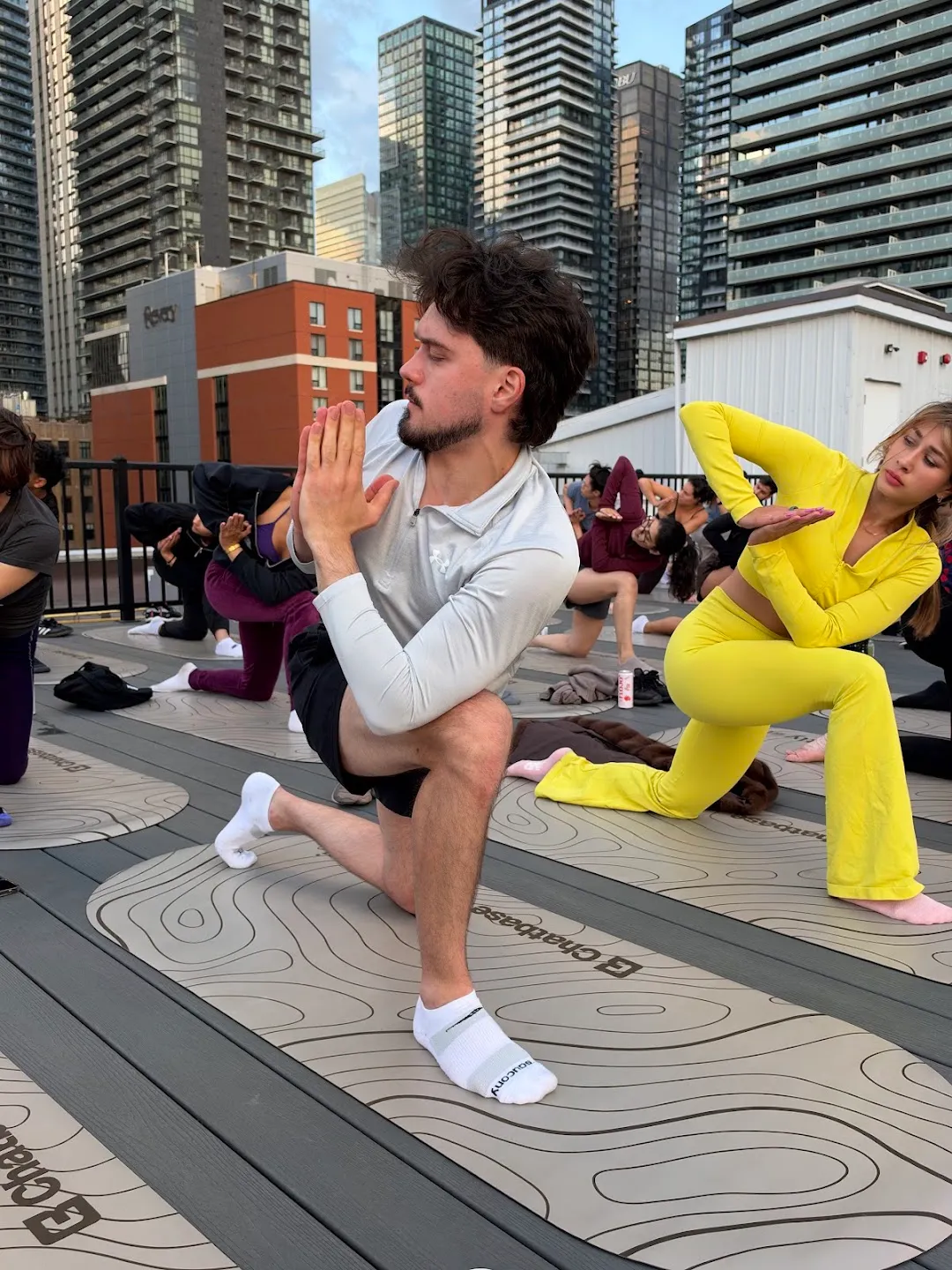 Participants stretching through standing yoga poses against the Toronto skyline