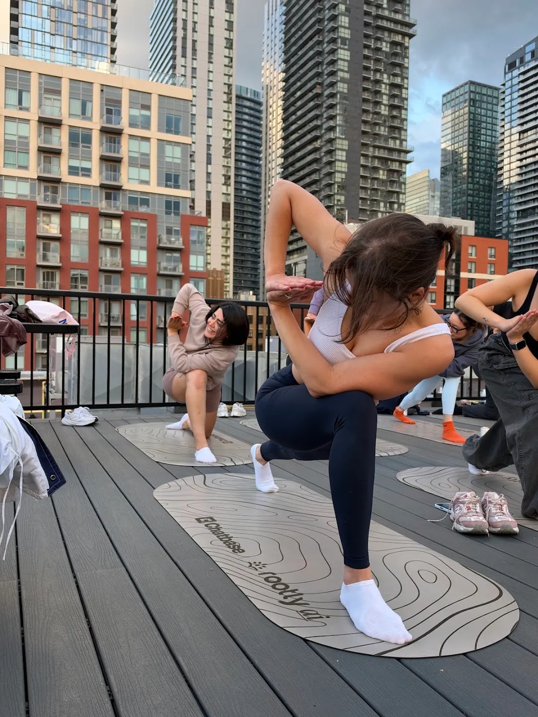 Participants stretching through standing yoga poses against the Toronto skyline