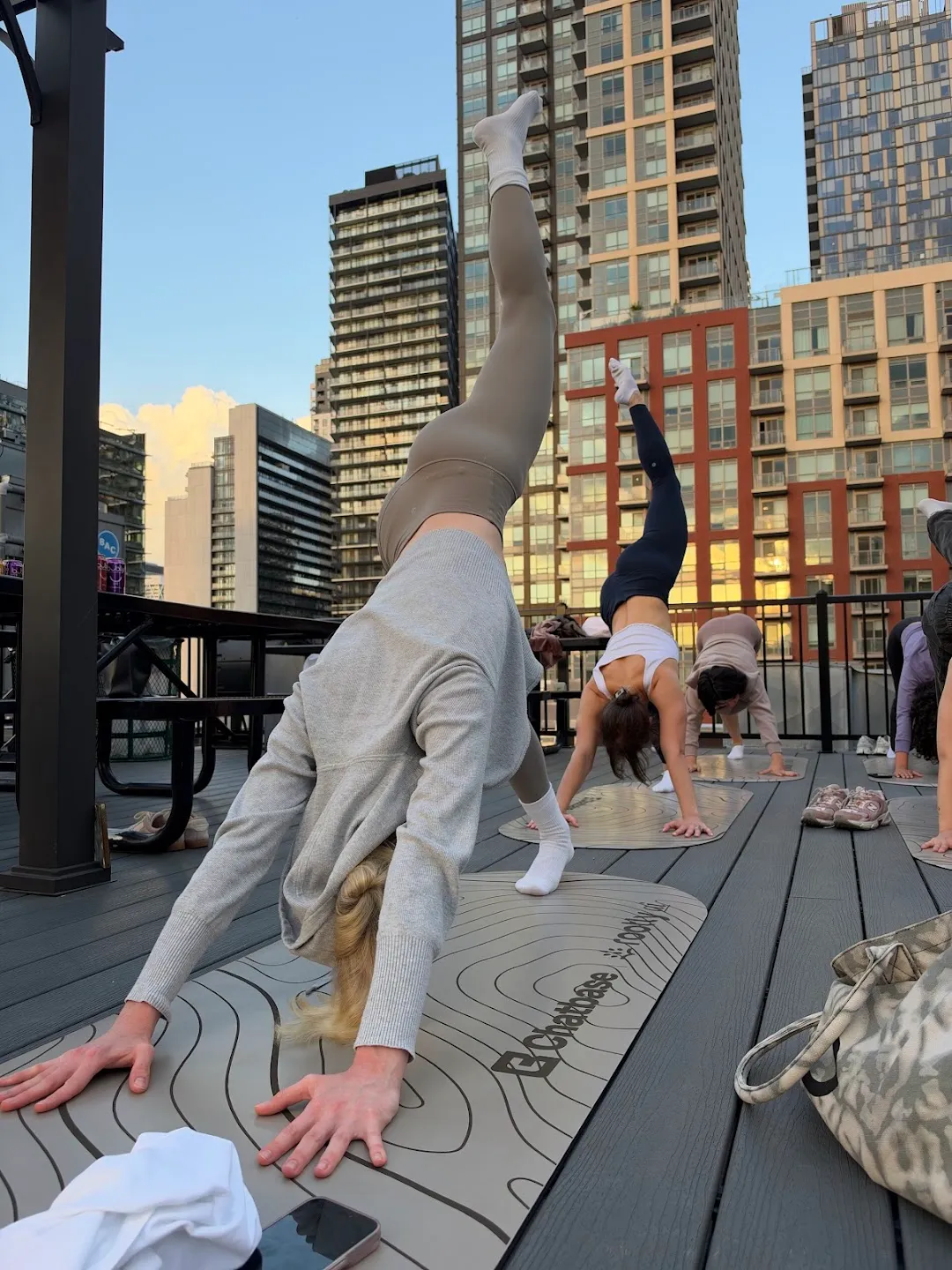 Participants stretching through standing yoga poses against the Toronto skyline