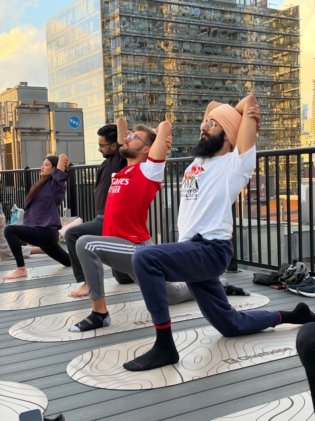 Participants stretching through standing yoga poses against the Toronto skyline