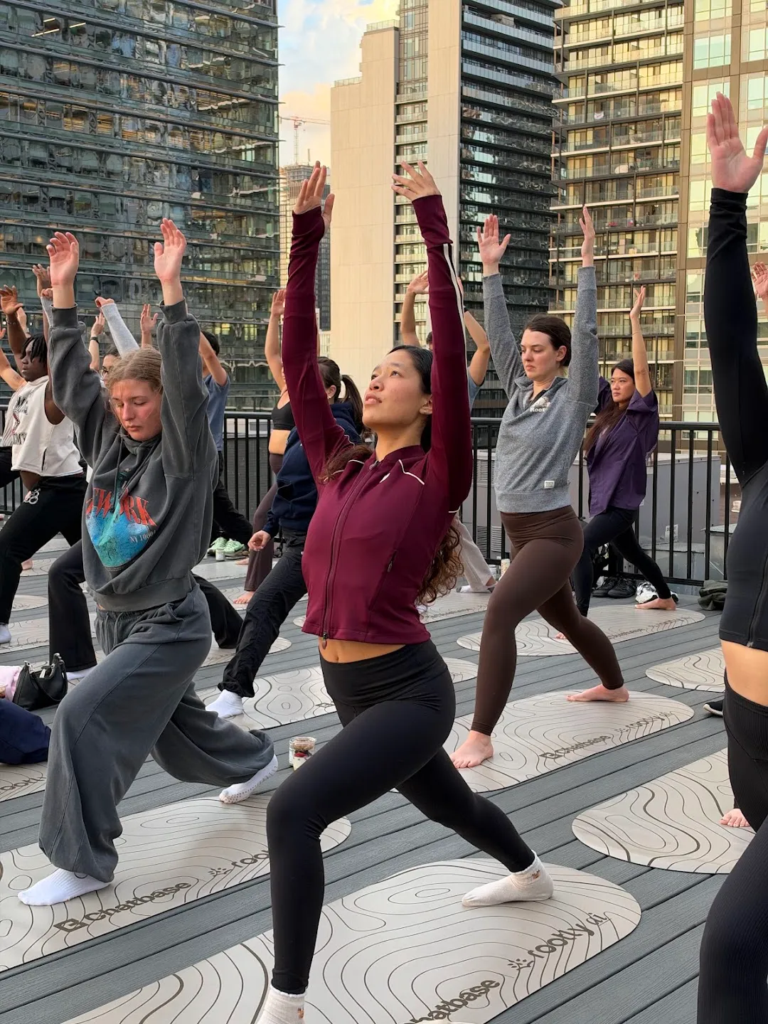 Participants stretching through standing yoga poses against the Toronto skyline