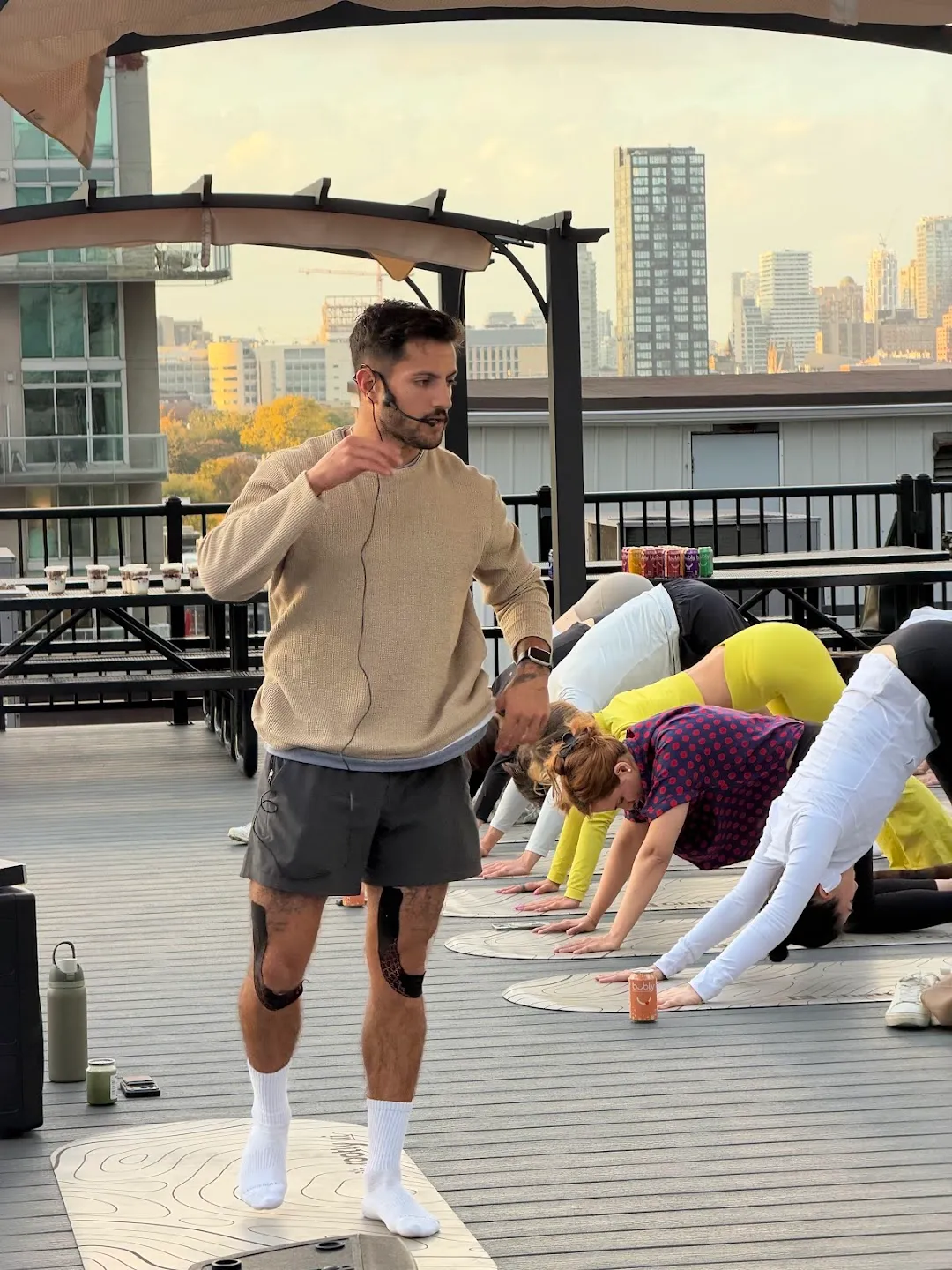 The yoga instructor addressing the rooftop class