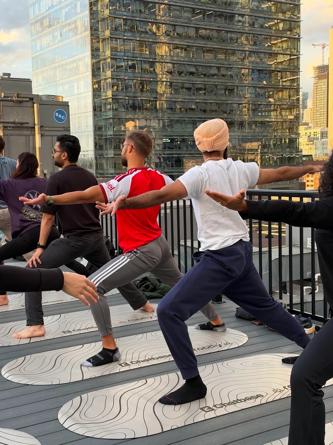 Participants stretching through standing yoga poses against the Toronto skyline