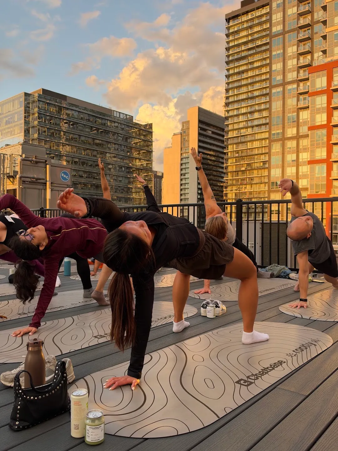Participants stretching through standing yoga poses against the Toronto skyline