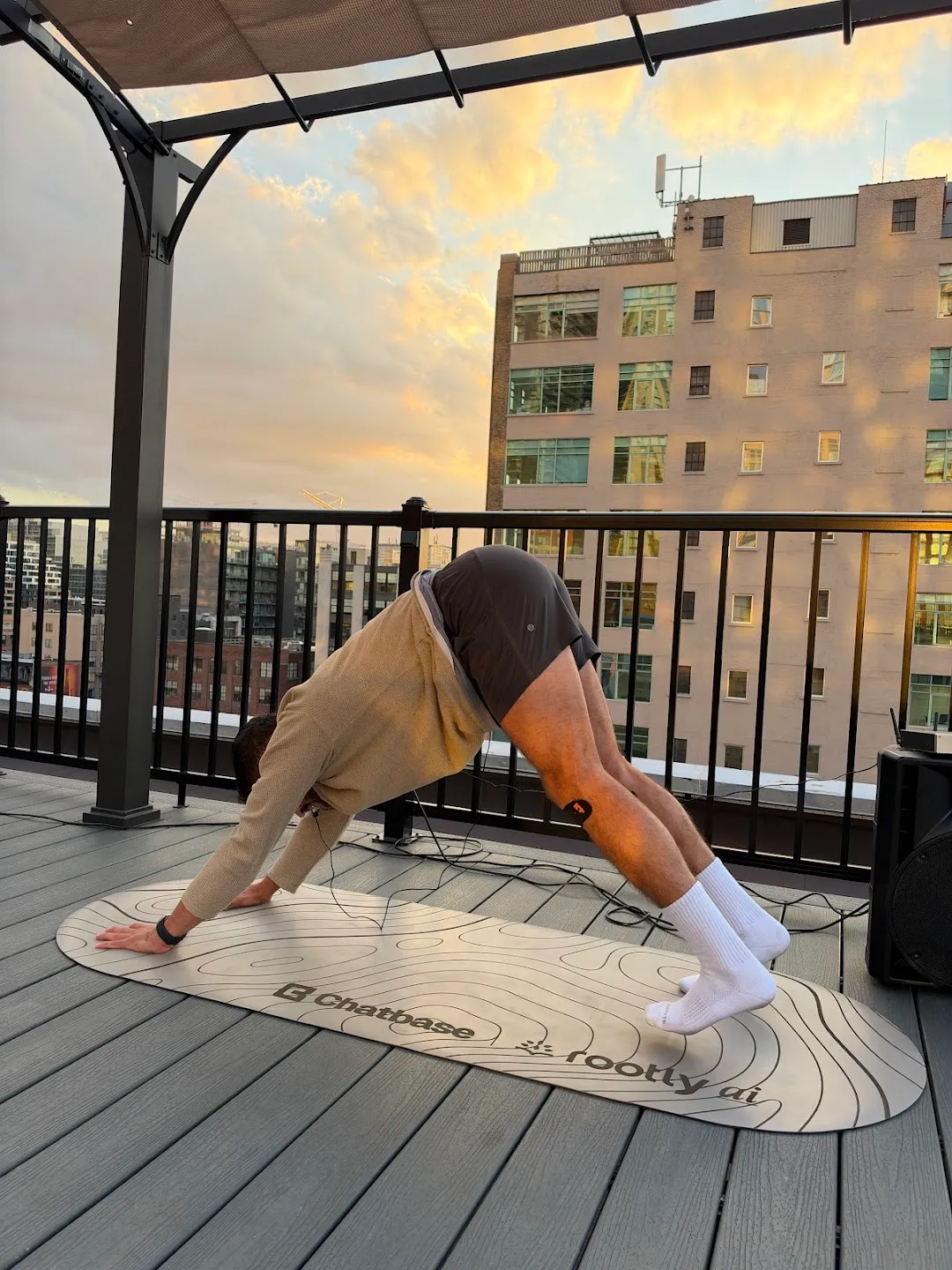 A participant stretching into downward-facing dog on the rooftop