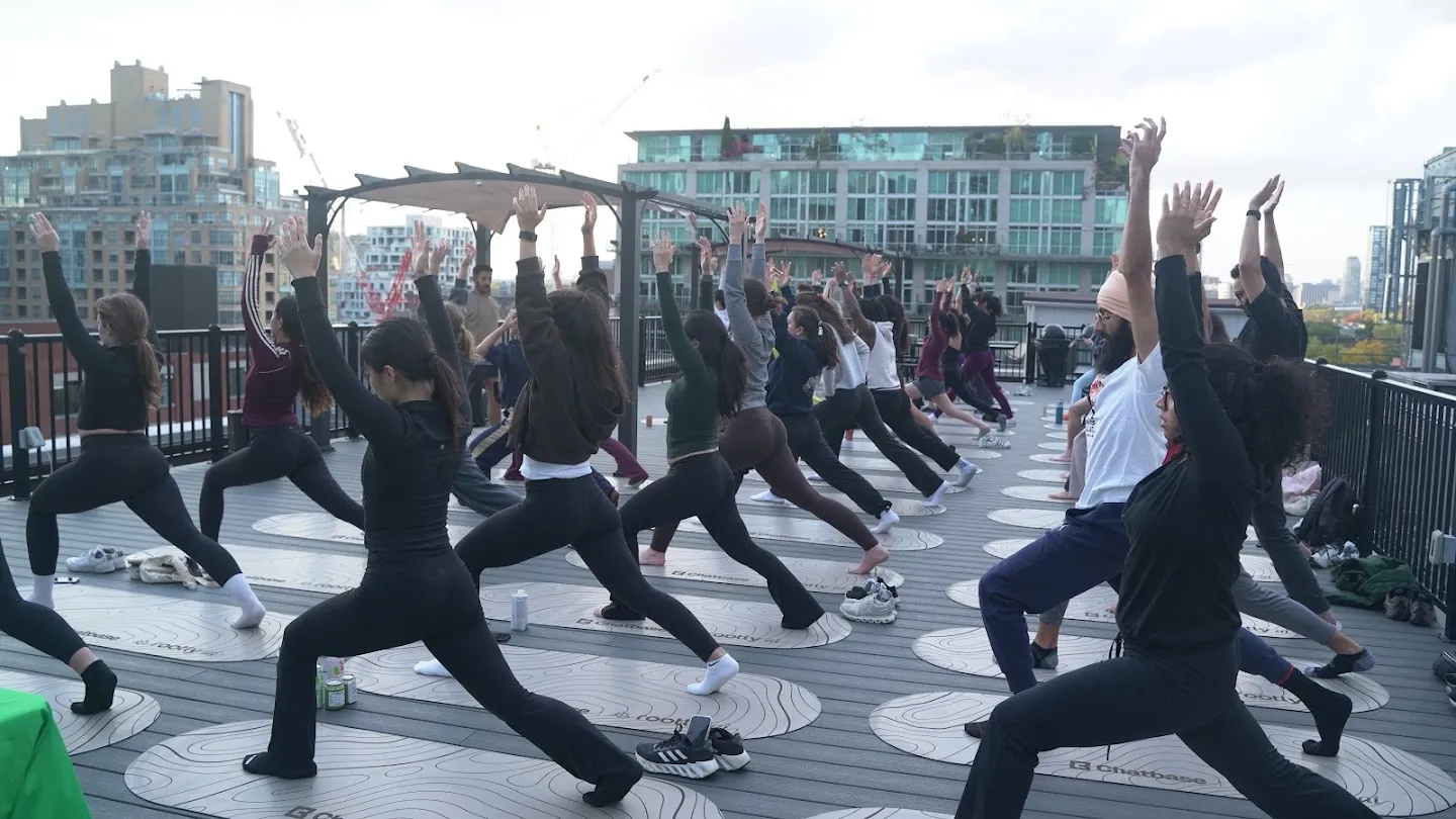 Participants stretching through standing yoga poses against the Toronto skyline