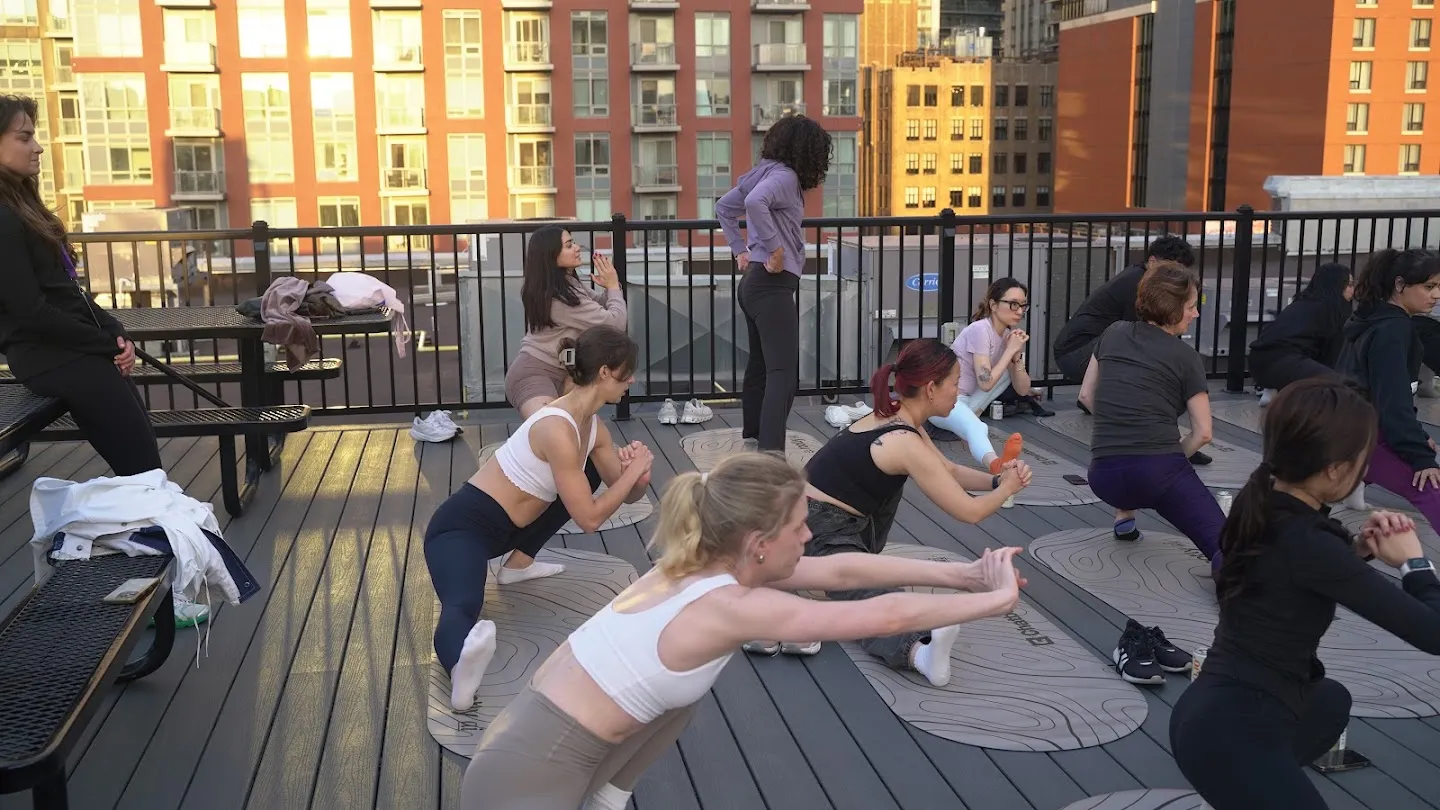 Participants stretching through standing yoga poses against the Toronto skyline