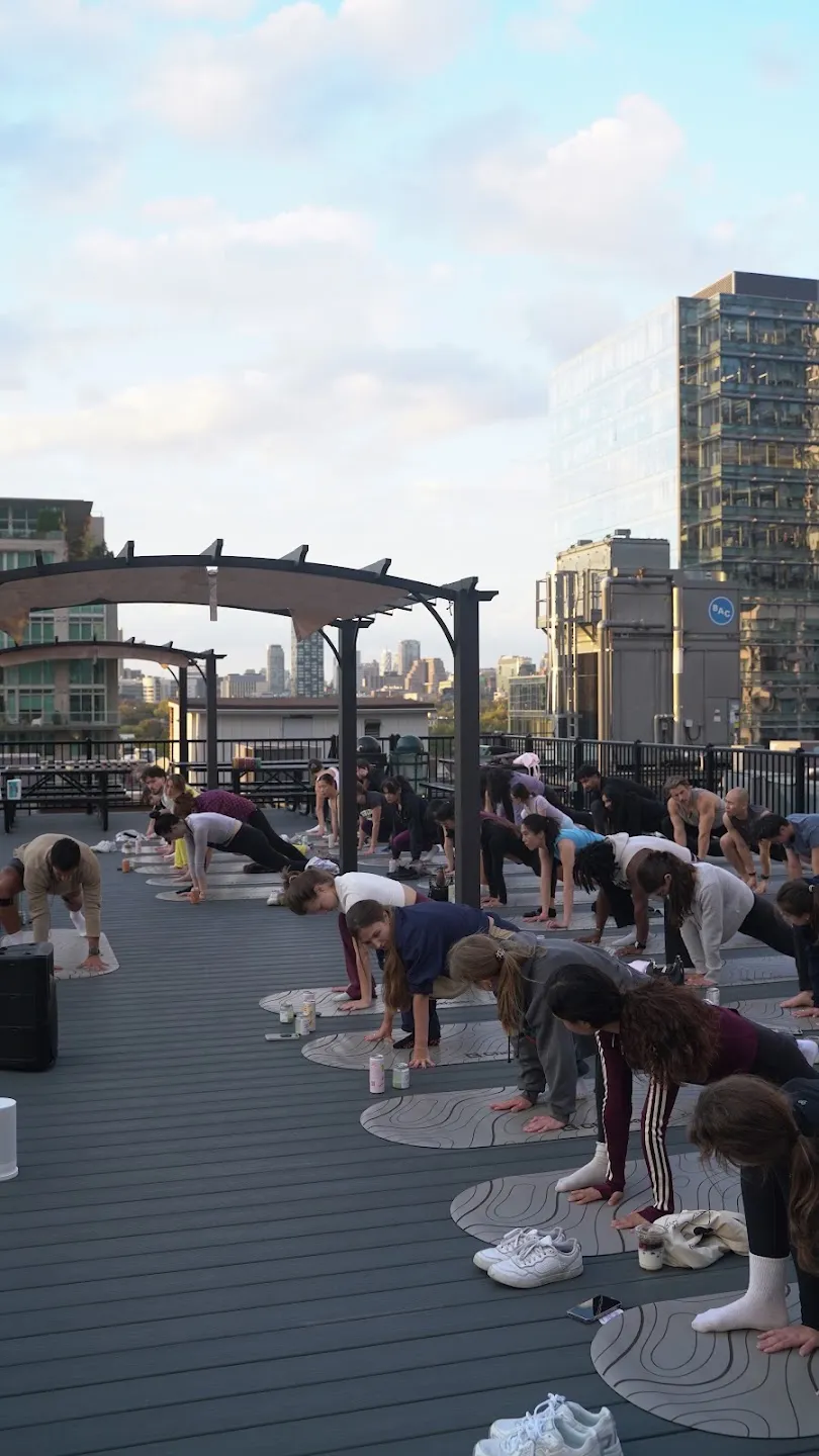 A view across the rooftop yoga class and city skyline