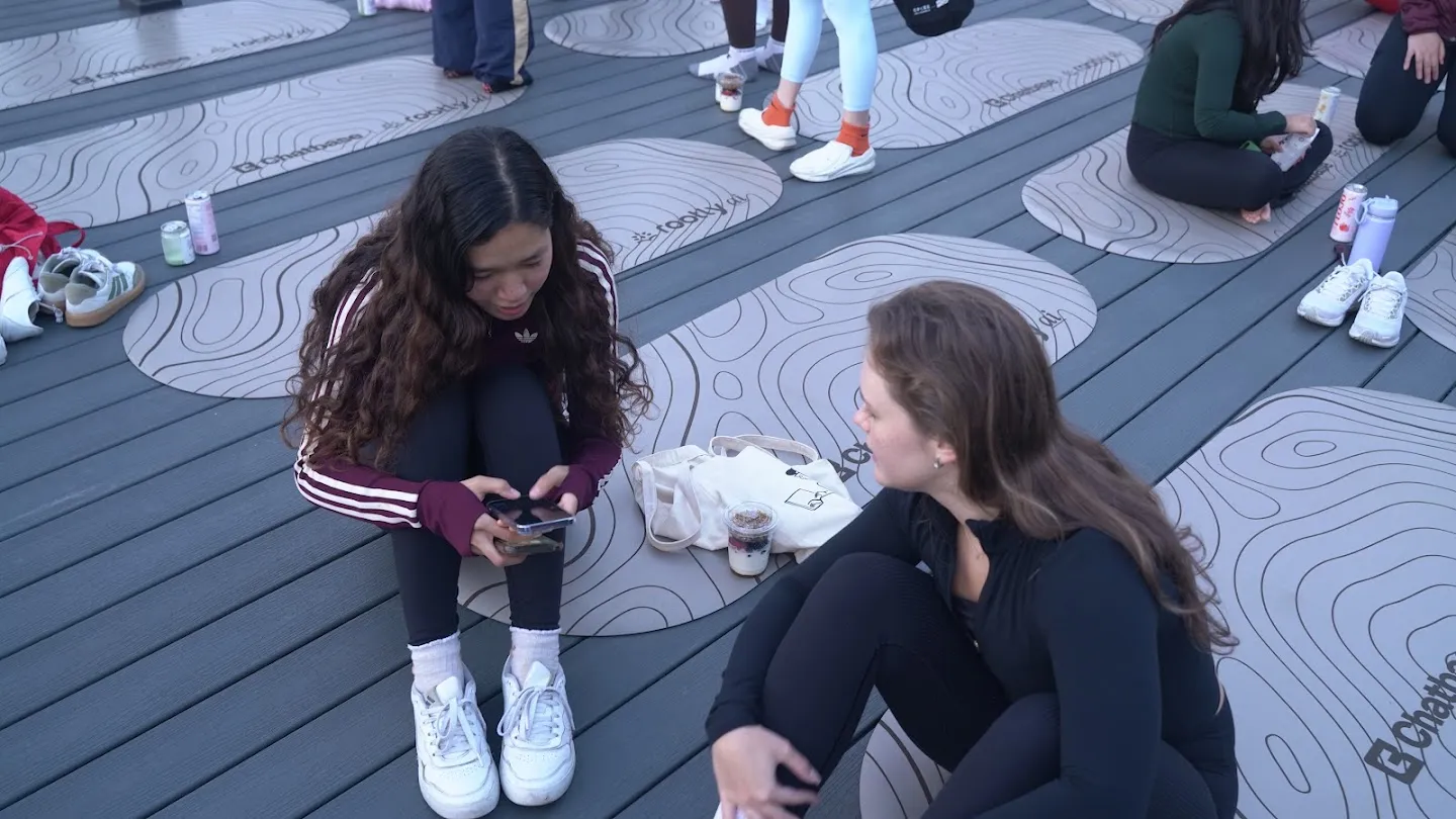 Two guests talking beside their yoga mats