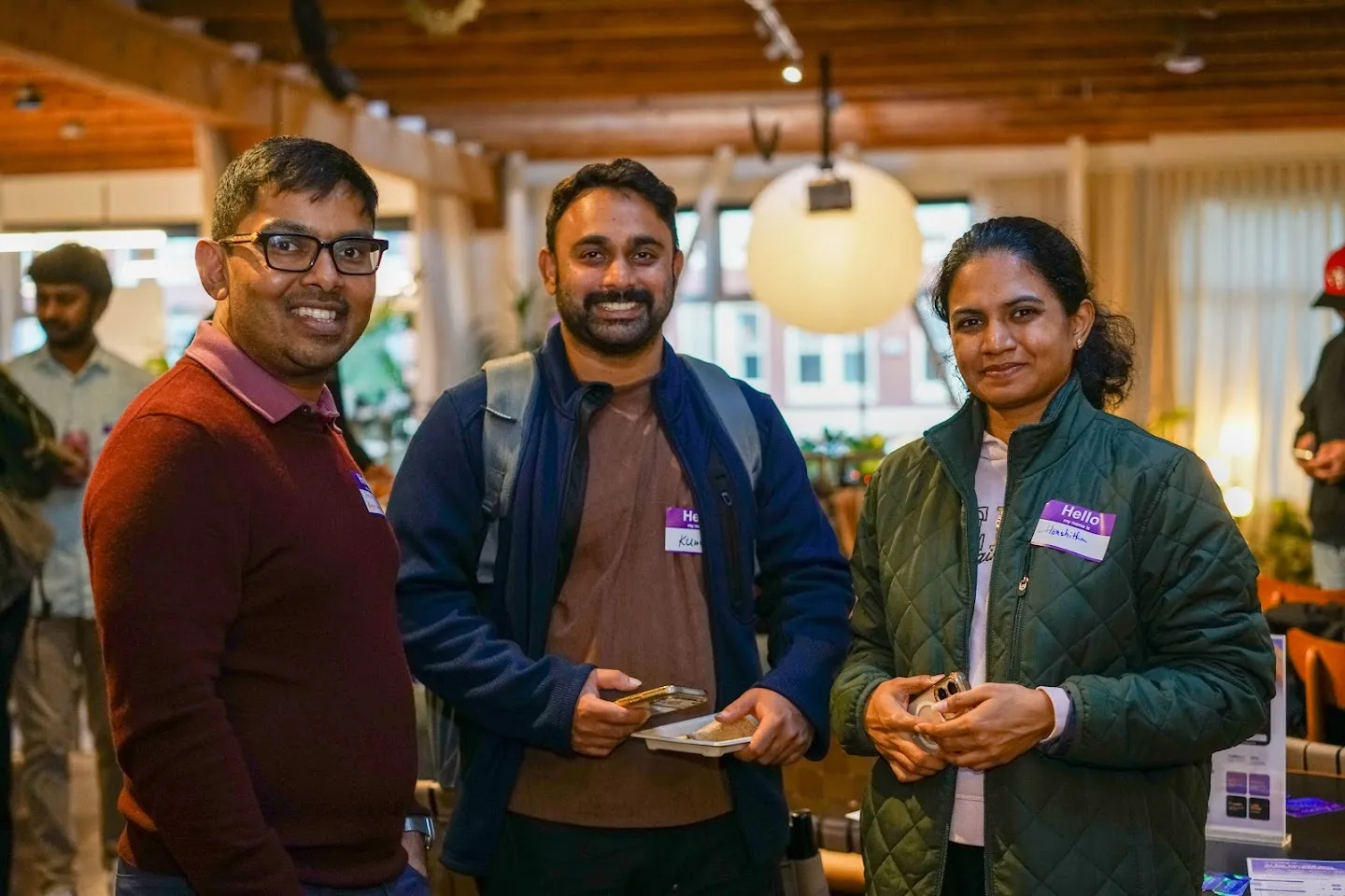 Three guests posing together with refreshments