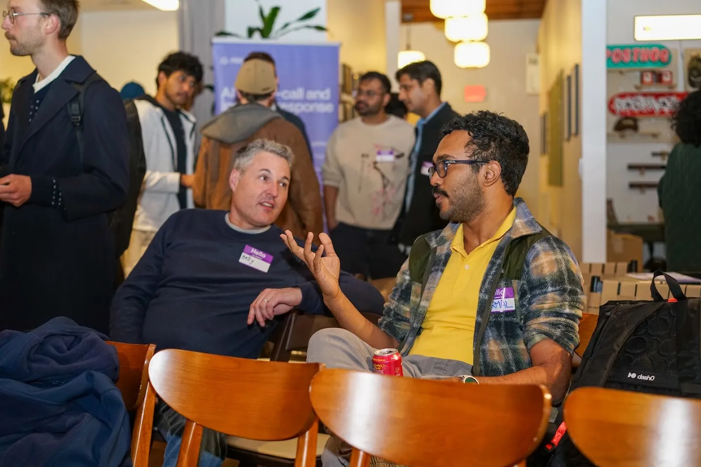Two attendees talking from lounge chairs