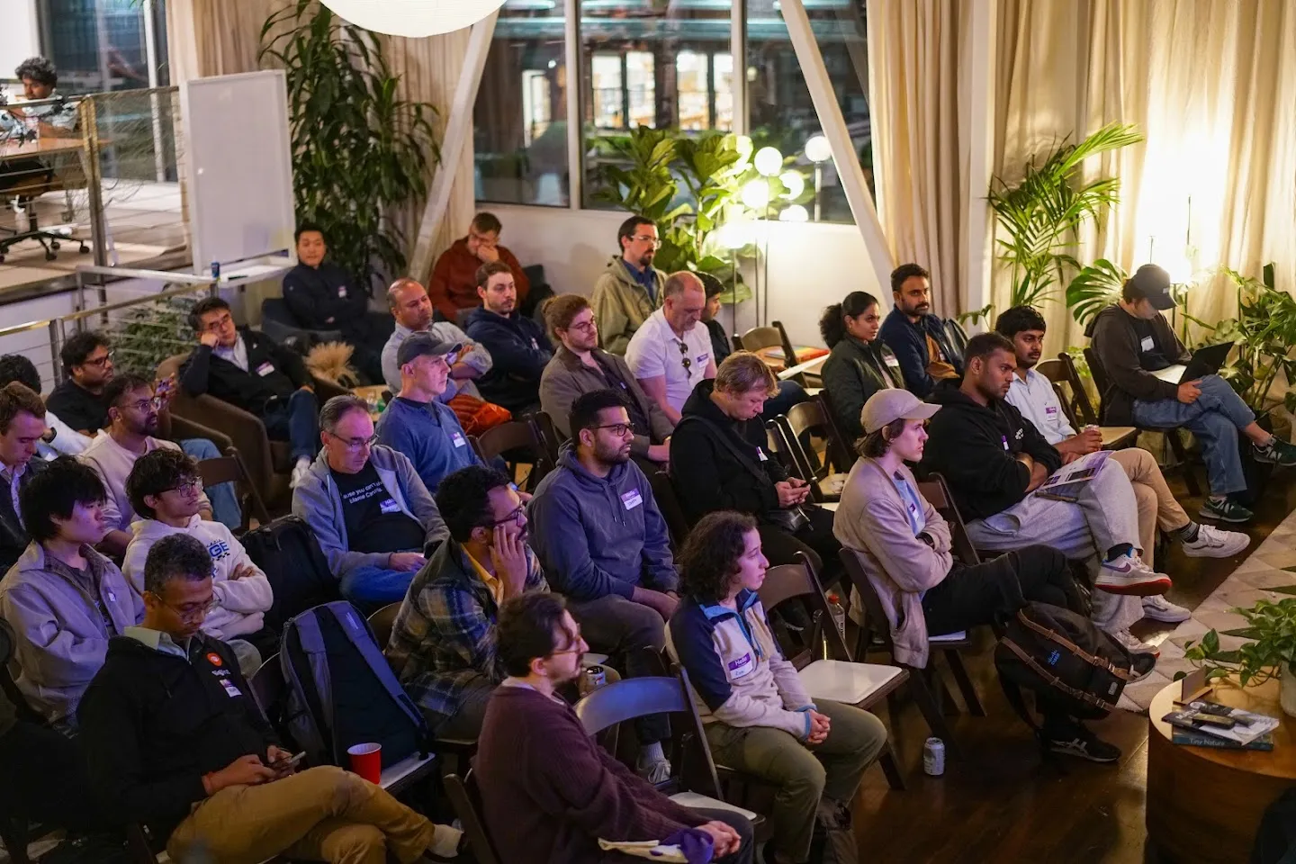 Attendees watching the discussion from rows of lounge chairs