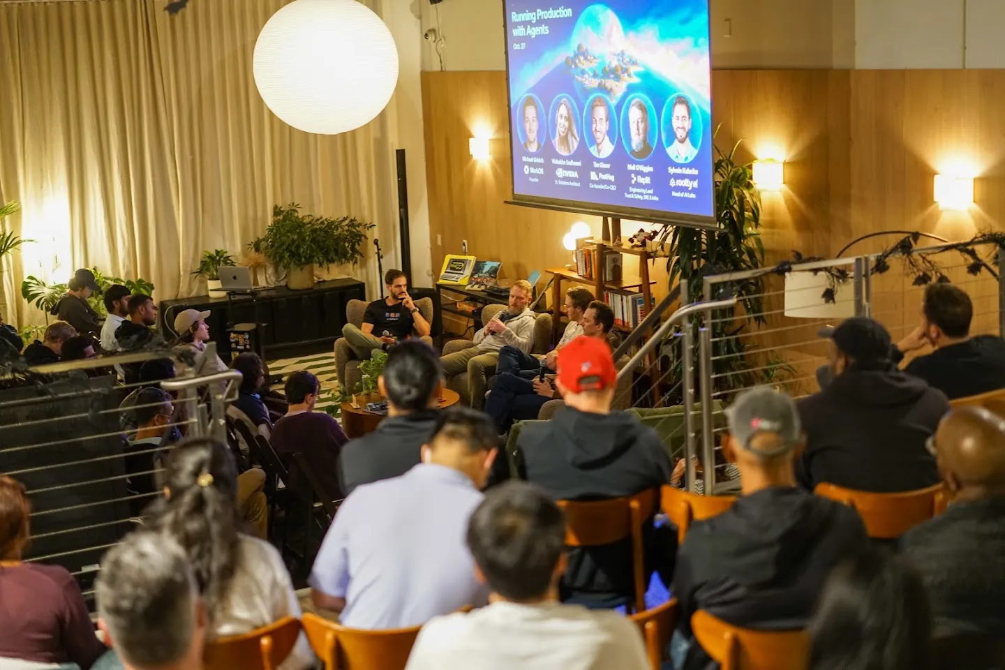 The audience facing the panel beneath the event screen