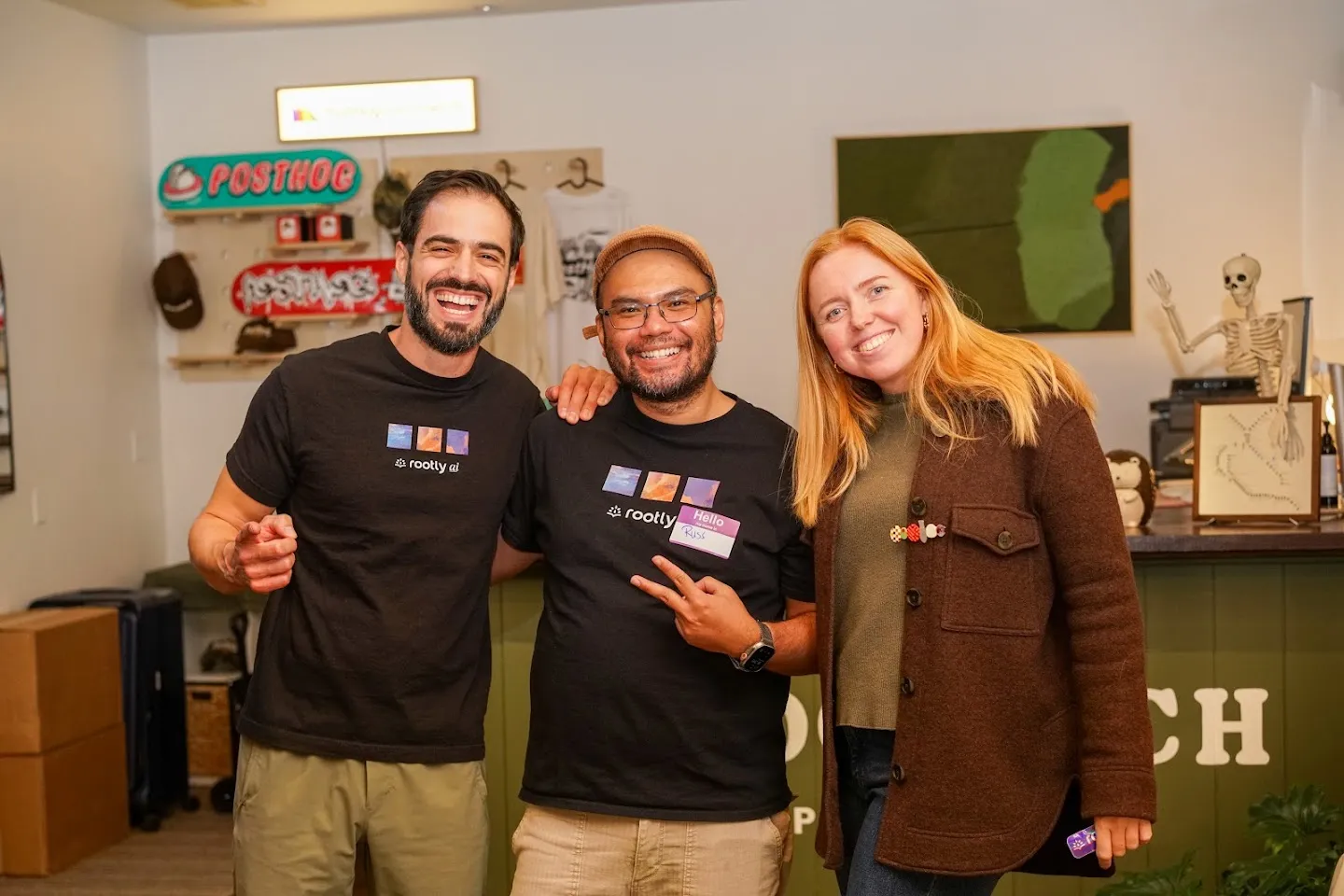 Three guests posing beside the PostHog counter