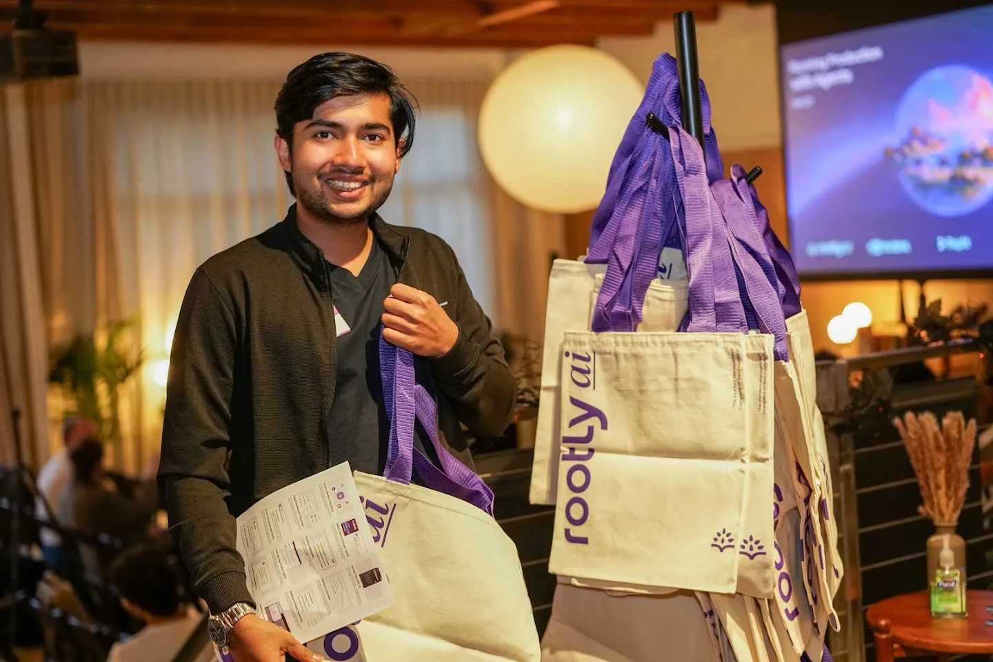 An attendee holding Rootly tote bags and an umbrella