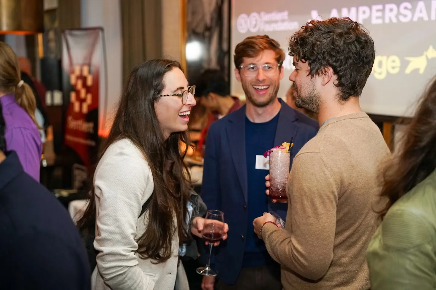Guests talking around the bar and library shelves at Novela